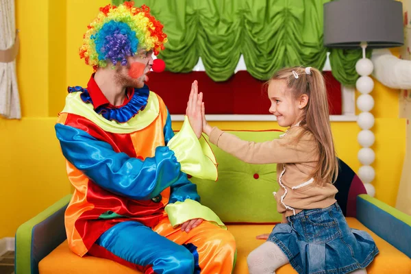 Flicka och clown spelar palms — Stockfoto