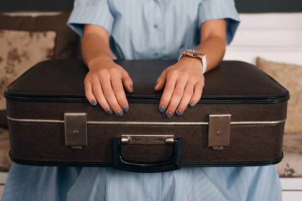 Kanepede oturan ve bavul tutan kadın — Stok fotoğraf