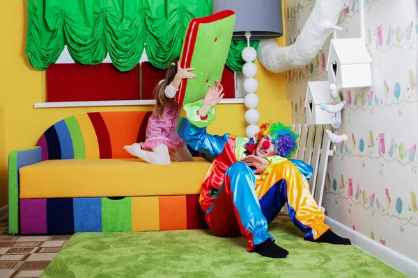 Lilla flickan slog clown med kudde — Stockfoto