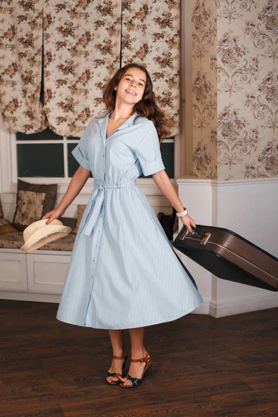 Женщина с чемоданом в винтажном интерьере — стоковое фото