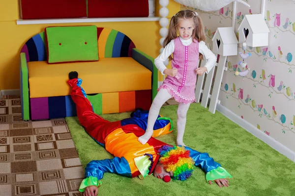 Girl with leg on clown's back — Stock Photo, Image