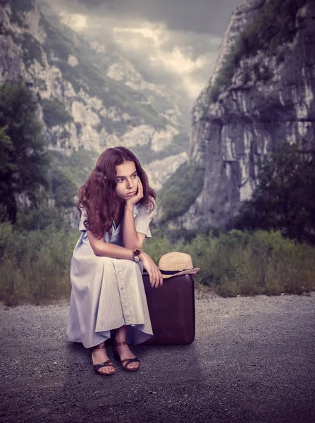 Femme assise sur une valise en forêt — Photo