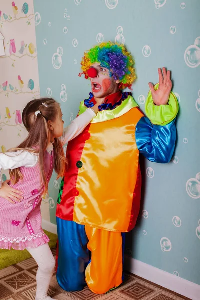 Cruel little girl playing with clown — Stock Photo, Image