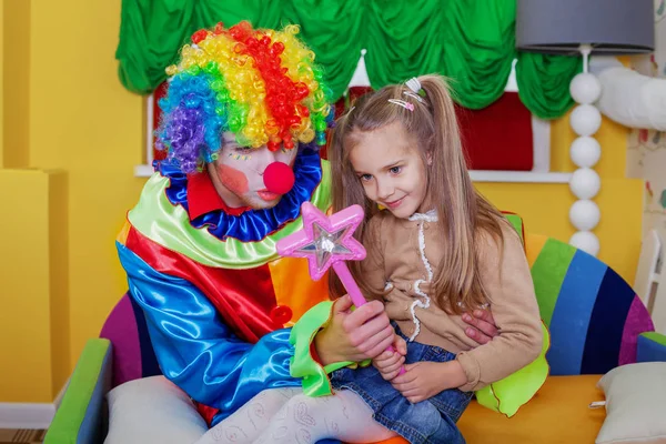 Ragazza che gioca con clown allegro — Foto Stock