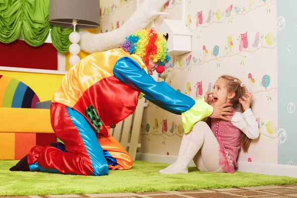 Cruel clown strangling little girl — Stock Photo, Image