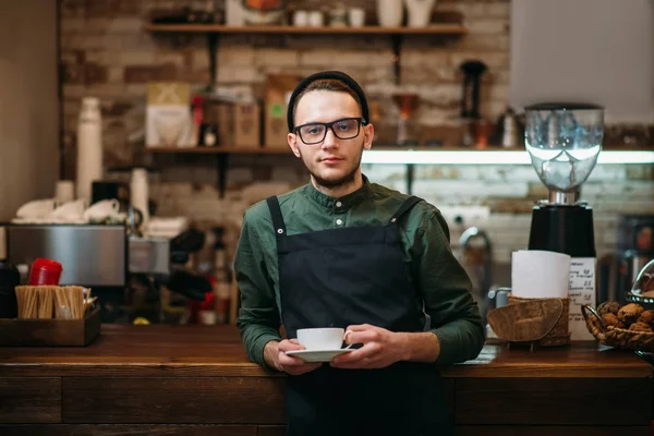 バリスタは、コーヒーのカップを保持しています。 — ストック写真