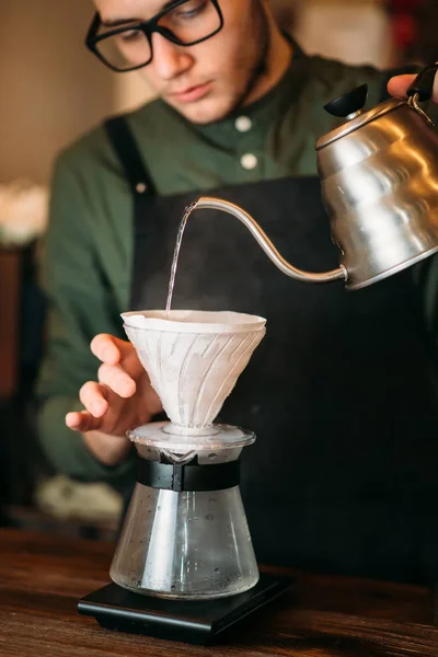 Waiter pours water in a coffee pot — Stock Photo, Image
