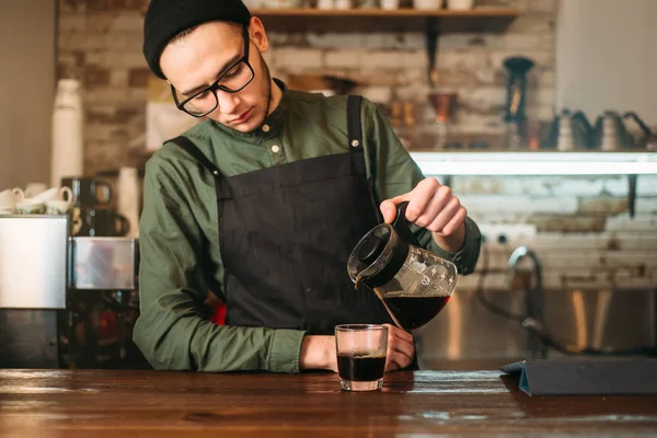 Barman derrama café em um copo — Fotografia de Stock