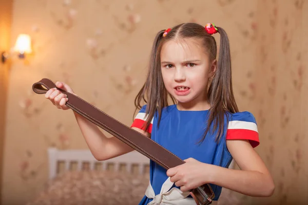 Niña enojada sosteniendo el cinturón —  Fotos de Stock