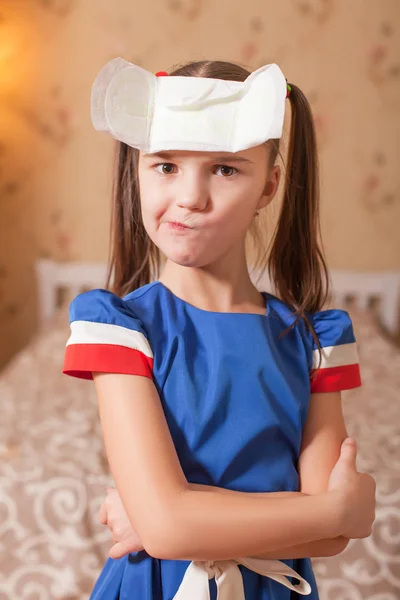 Little girl with menstrual pad on forehead — Stock Photo, Image