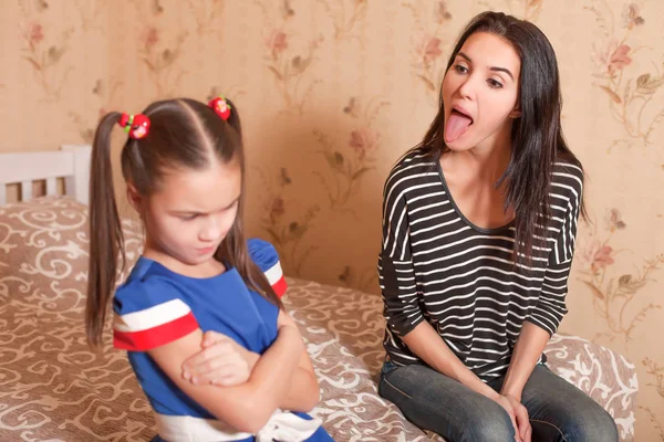 Mãe mostrando língua para filha — Fotografia de Stock