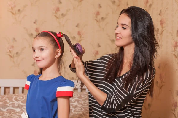 Mãe fazendo penteado para filha — Fotografia de Stock