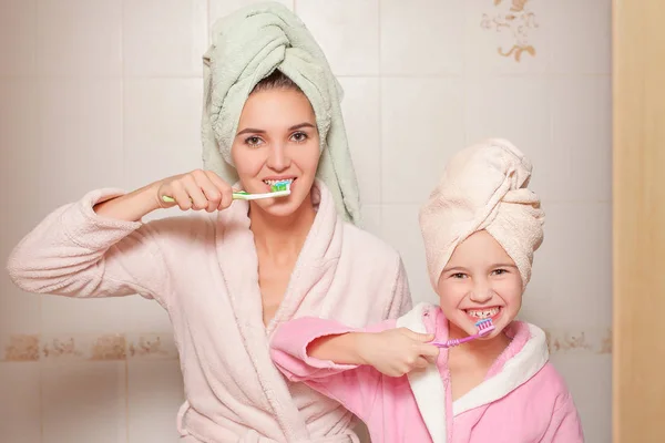 Madre e hija pequeña cepillándose los dientes —  Fotos de Stock