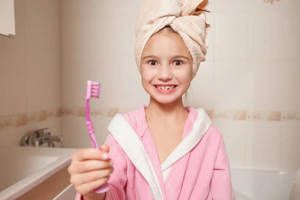 Niña sosteniendo el cepillo de dientes en el baño — Foto de Stock