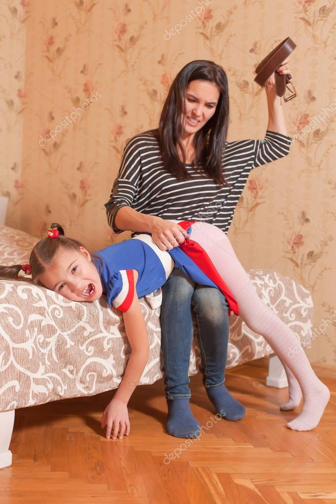 Mother trying to hit daughter with belt — Stock Photo ...