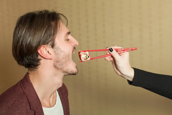 Fêmea mão alimentando o homem com sushi — Fotografia de Stock