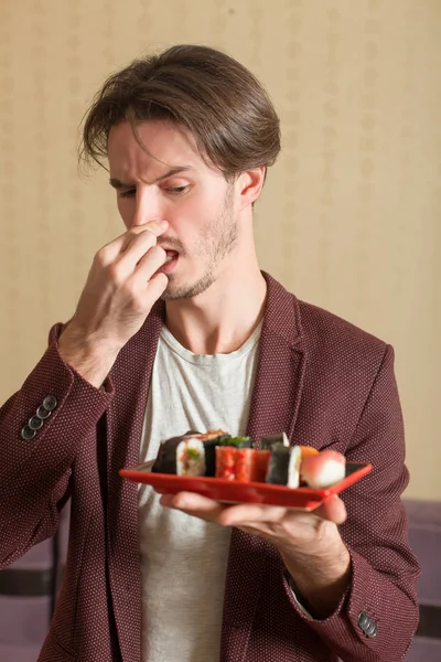 Ung man äter sushi — Stockfoto