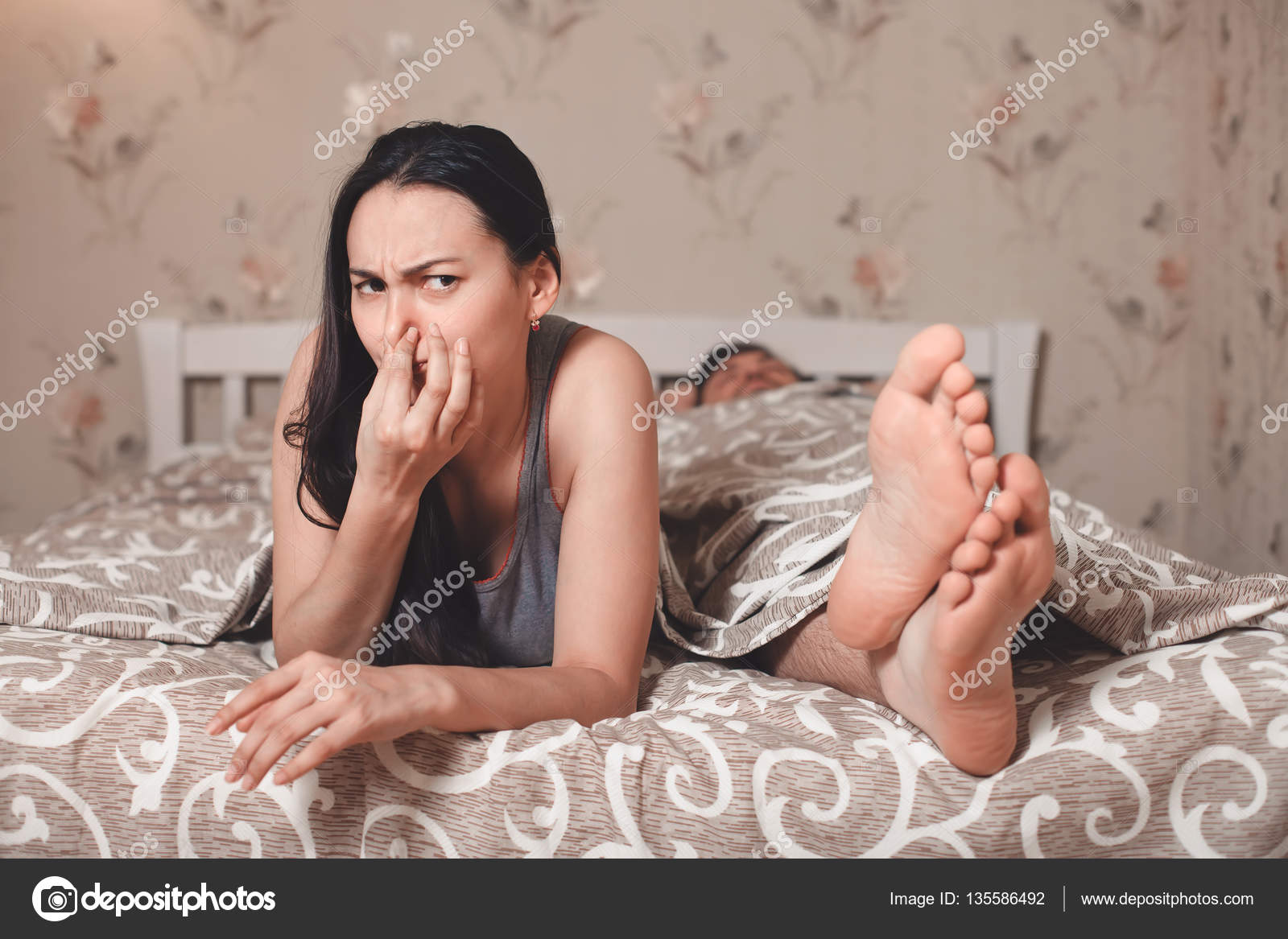 wife closing nose beacause of smell from feet stock photo