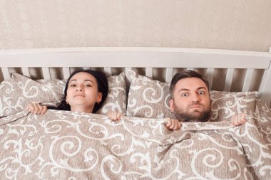 Genç çift yatakta yatıyor.