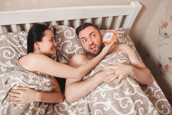 Woman showing alarm clock to husband — Stock Photo, Image