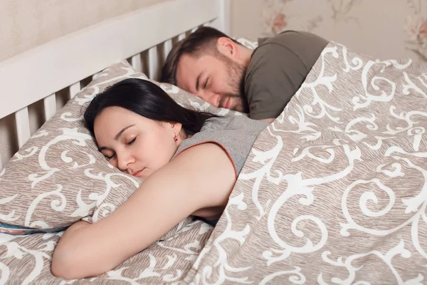 Homem e mulher dormindo na cama — Fotografia de Stock