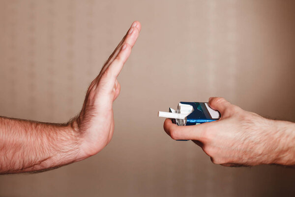 man refusing offered cigarettes