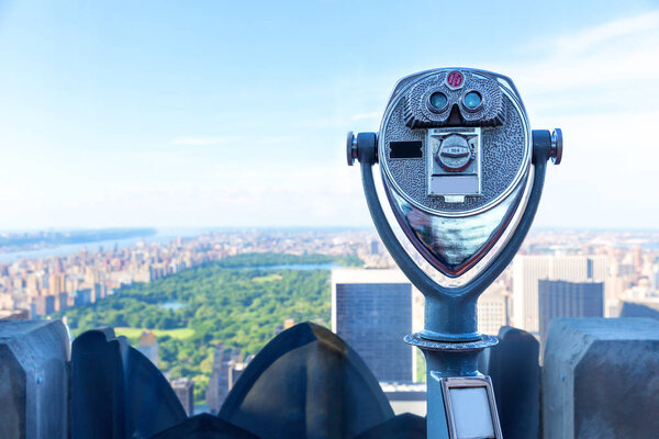 Observation coin operated binoculars at viewing point against blur city skyline