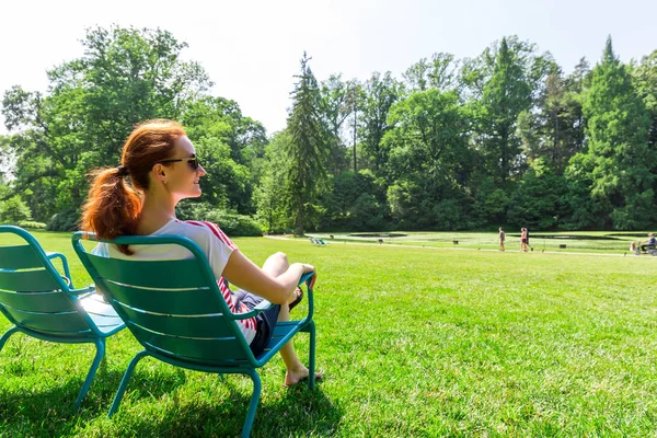 Fiatal nő pihentető nyári parkban — Stock Fotó