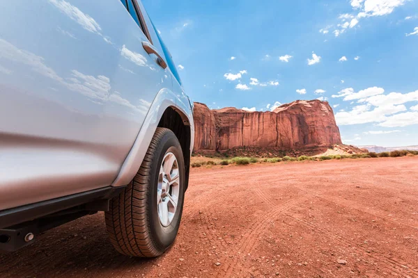 Coche en la carretera a lo largo de rocas rojas — Foto de Stock