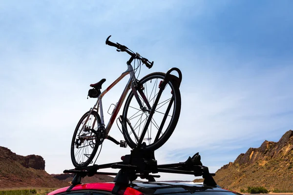 Bil med cykeln mot blå himmel — Stockfoto