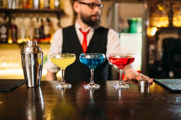 Barman y tres bebidas en copas de vino —  Fotos de Stock