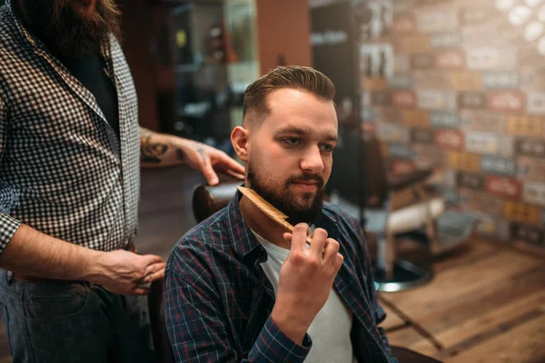 Клієнт розчісує свою бороду в перукарні — стокове фото