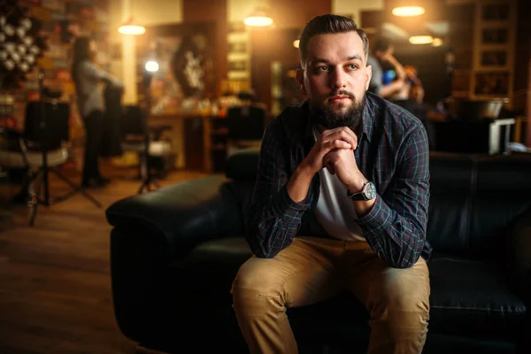 Bearded man sitting on black couch — Stock Photo, Image