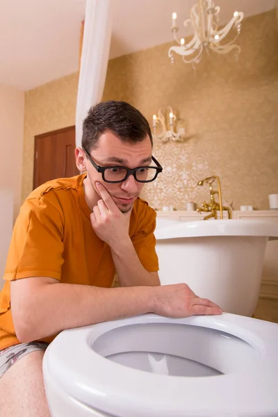 Homme regardant dans le bol des toilettes — Photo