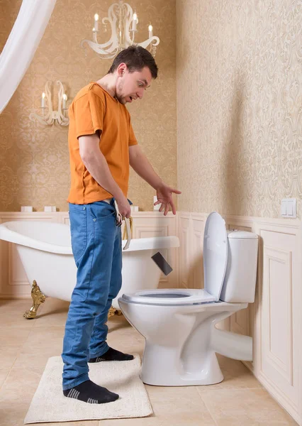 Man dropping cell phone in toilet bowl — Stock Photo, Image