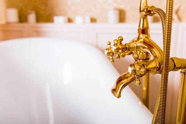 Goldglänzender Wasserhahn und weißes Bad — Stockfoto