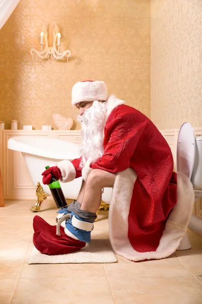 Julenissen sitter på toalettet – stockfoto
