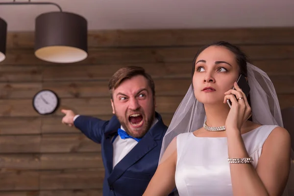 Bride talking over phone and groom shouting — Stock Photo, Image
