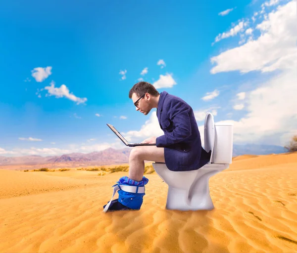 Ο άνθρωπος με το laptop κάθεται στην λεκάνη της τουαλέτας — Φωτογραφία Αρχείου