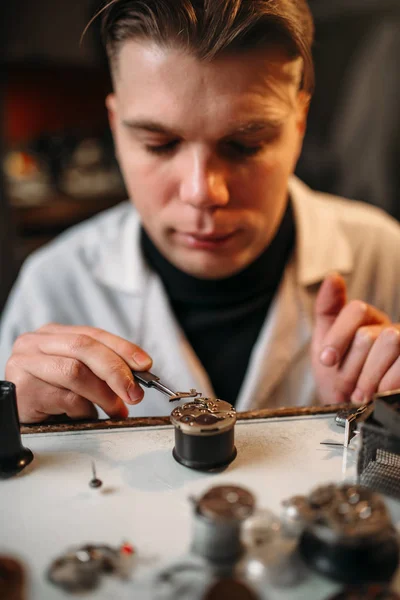 Watchmaker with old clock — Stock Photo, Image