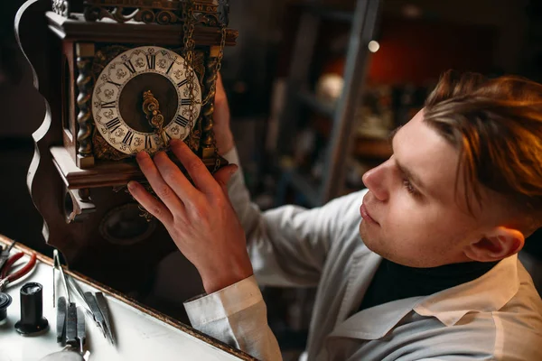 Watchmaker with old clock — Stock Photo, Image