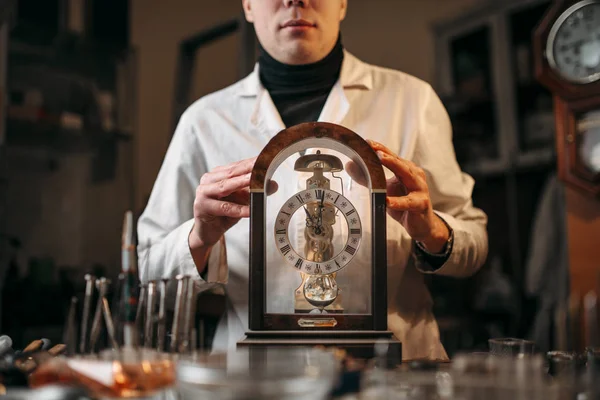 Watchmaker with old clock — Stock Photo, Image