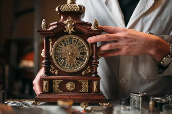 Watchmaker with antique clock — Stock Photo, Image