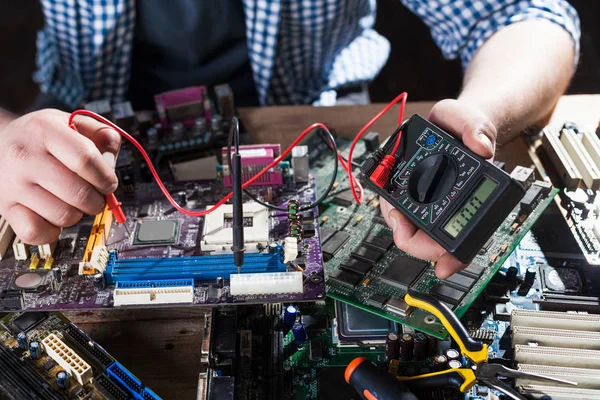 Engineer making diagnostics of laptop with multimeter — Stock Photo, Image