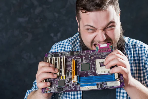 Ingenieur beißt Computermotherboard. — Stockfoto