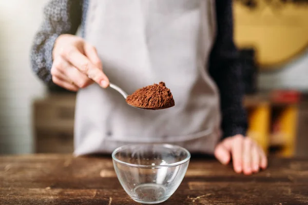 Hand holding spoon with chocolate powder — Stock Photo, Image