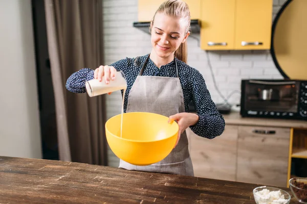 Woman adding milk into bowl — Stock Photo, Image