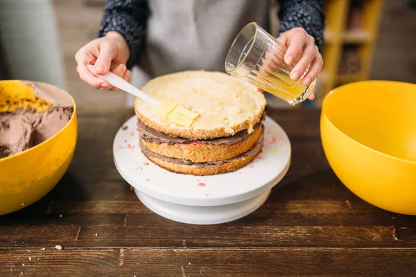 Tangan menuangkan sirup di atas kue — Stok Foto