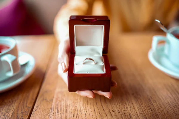 Mão segurando caixa com anel de casamento — Fotografia de Stock