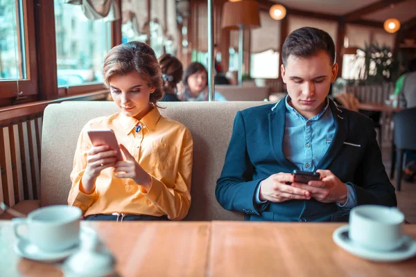 Pareja de amor utilizando teléfonos inteligentes en el restaurante —  Fotos de Stock